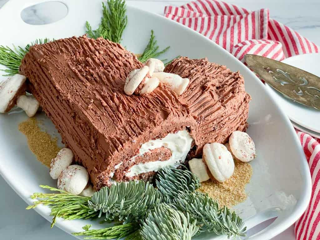 Yule log cake with striped linens and cake server. 