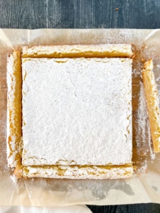 Lemon bars lifted out of the pan and the edges trimmed off.