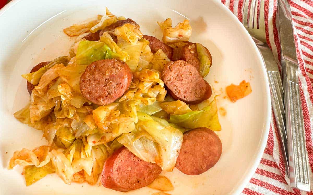 A bowl of cabbage and sausage.