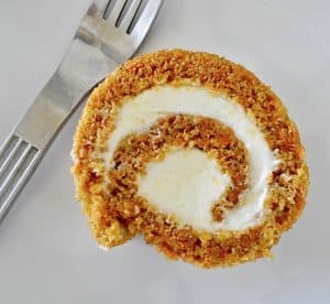 Carrot Cake Roll Slice on a white plate with a fork.