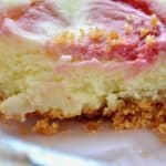 Sliced mini lemon cheesecake with raspberry swirl.