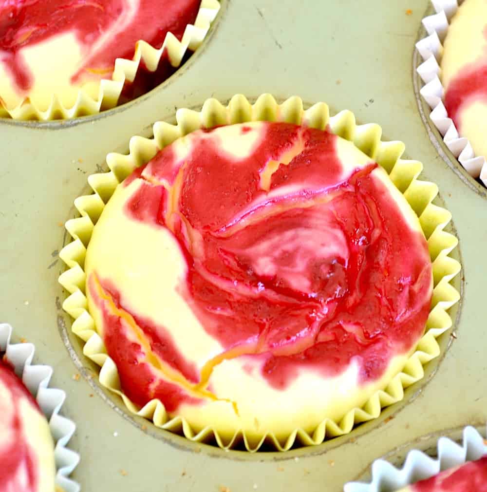 Mini Lemon Cheesecakes with Raspberry Swirl in a muffin tin before baking.