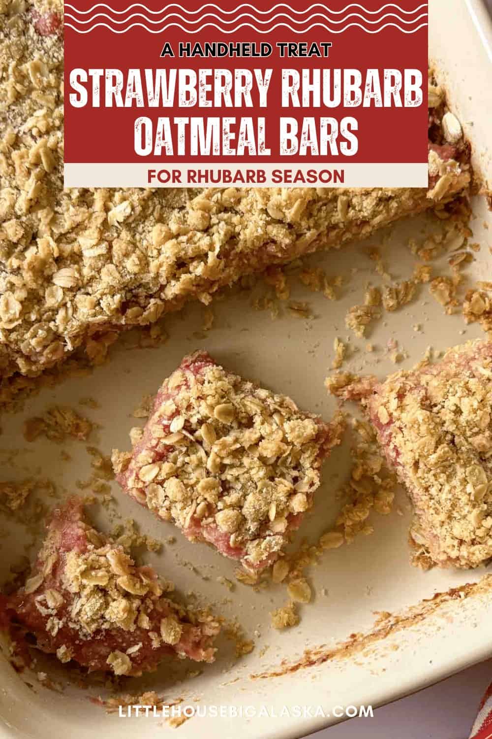 Close-up of Strawberry Rhubarb Bars in a baking dish, with one strawberry bar cut and slightly removed from the rest.