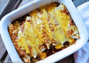 Beef and Bean smothered Burrito in a pan covered in sauce and cheese.
