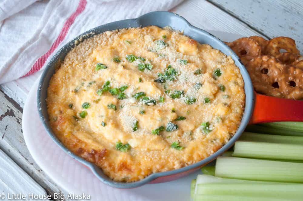 Jalapeño Popper Dip served with crisps and celery in oven proof pan