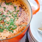 A pot of lasagna soup alongside serving bowls.
