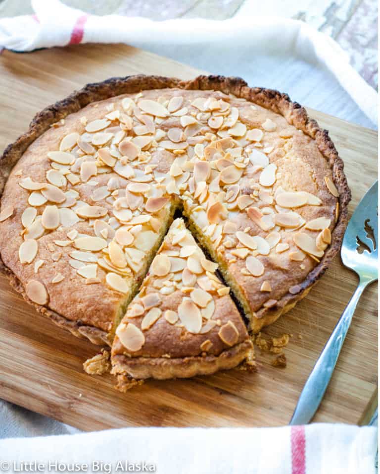 Bakewell tart with a slice out of it.