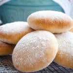 Freshly baked floury baps in a cooling tray.