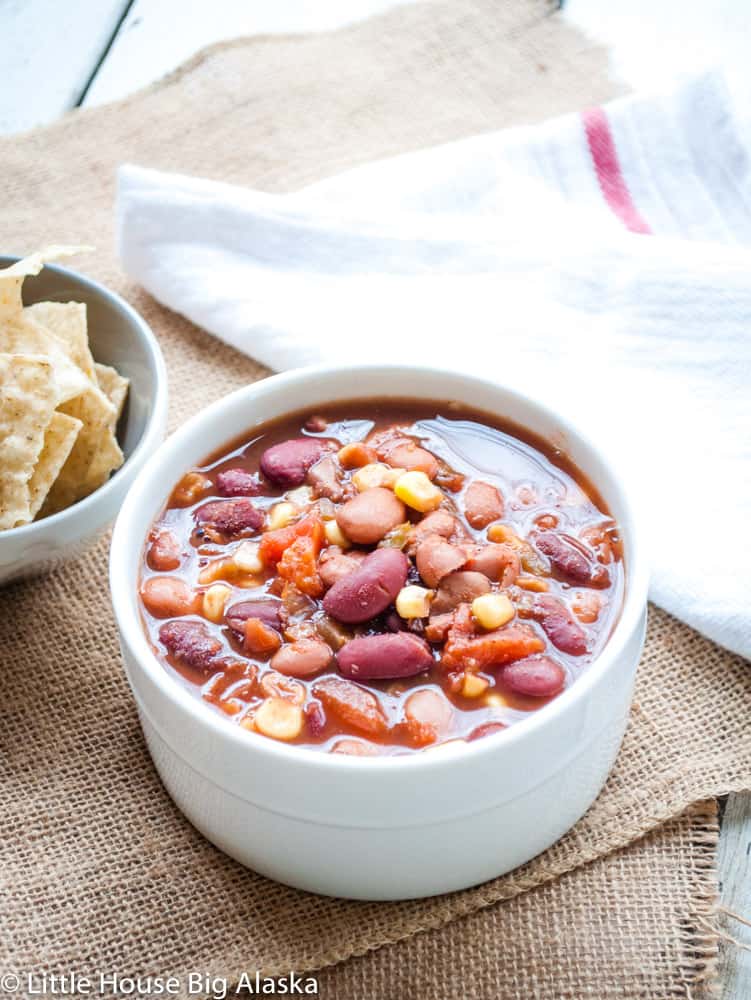 A bowl of crockpot vegan chili served with nachos on the side.