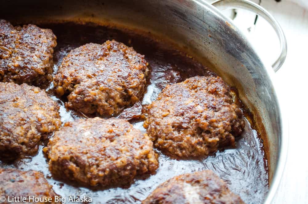 Salisbury steak with gravy in a skillet.
