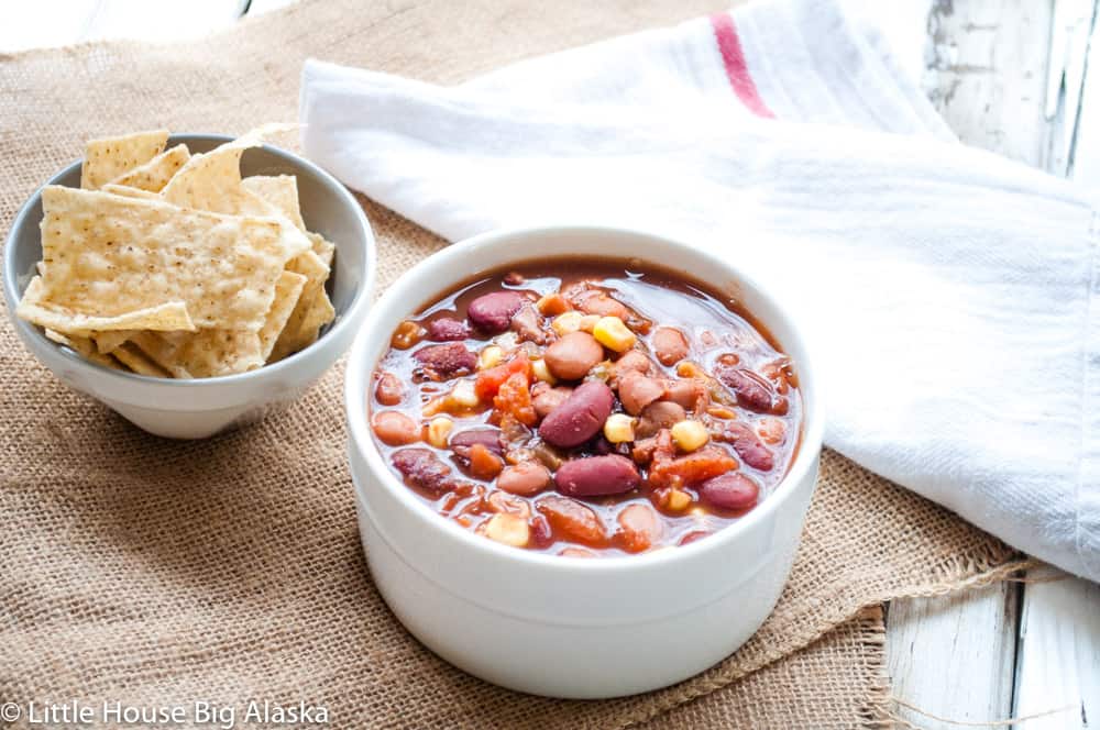 A fresh bowl of vegan chili with chips on the side.