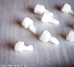 Shaping the marshmallows into mushrooms for mini yule log cake.