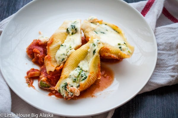 Cheese and spinach stuffed shells in a white plate.