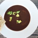 Black bean soup served with a pita bread.