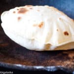 Puffed roti on a skillet.