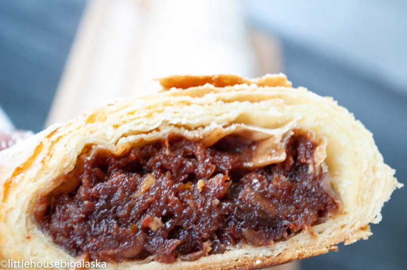 A slice of cherry strudel revealing its flaky layers and sweet cherry filling.