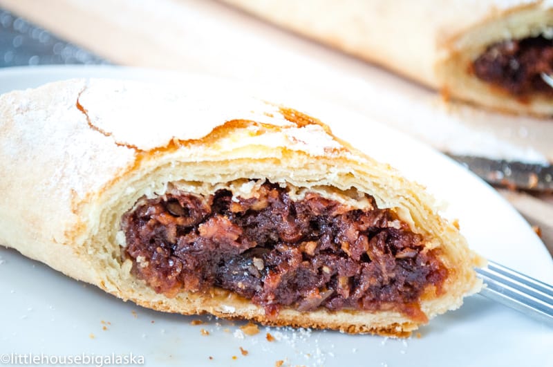 A slice of cherry strudel revealing its flaky layers and sweet cherry filling.