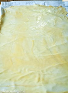 Melted butter drizzled over the thin dough.