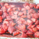 Steaming hot roasted strawberries, with caramelized edges and vibrant color, fresh out of the oven.