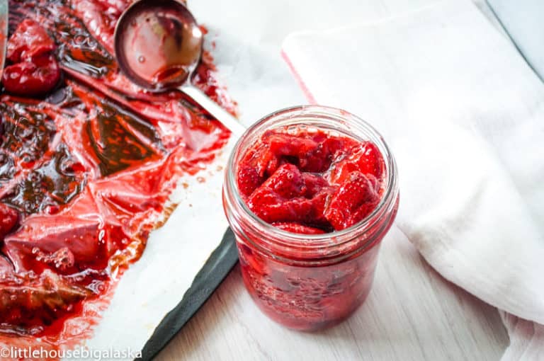 A jar of roasted strawberries scooped out from the pan.