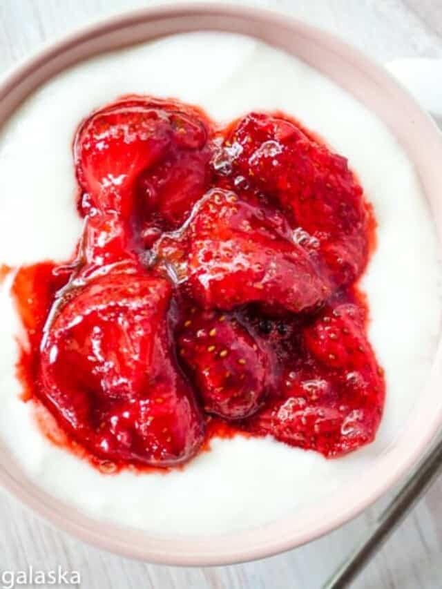 A bowl of yogurt with strawberries in it.