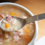 Instant Pot Navy Bean SOup Recipe in big white bowl in front of Instant Pot Pressure cooker system