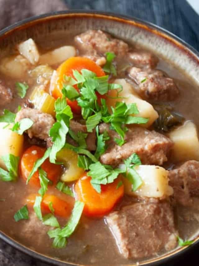 Irish beef stew in a bowl with carrots and potatoes.