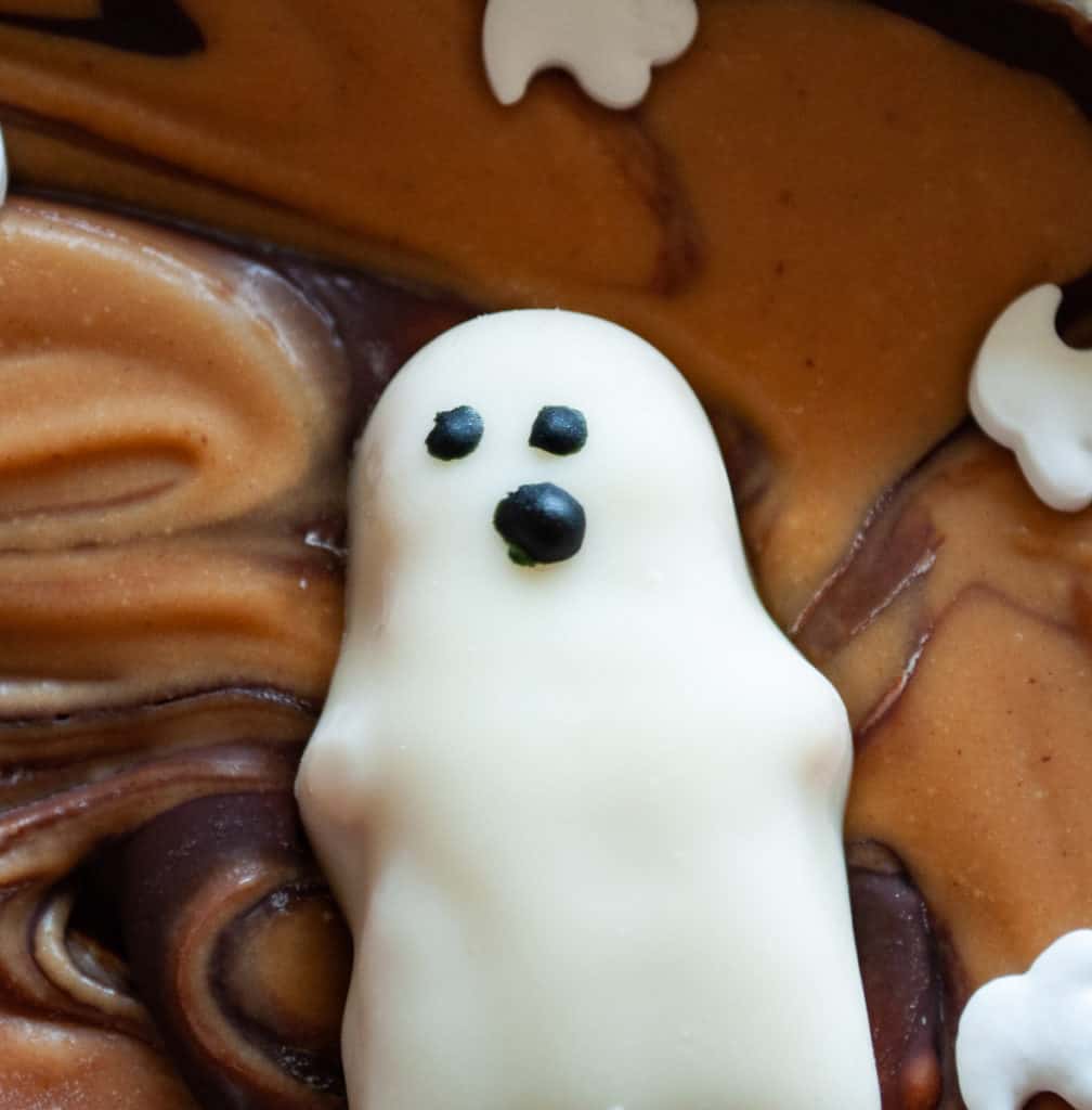 A peanut butter ghost in white chocolate with a face.