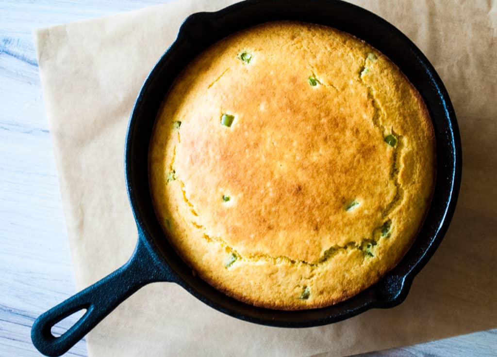 a cast-iron skillet with jalapeño studded cornbread hot and fresh out of the oven. 