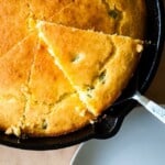 Freshly baked bread with a slice out of it.