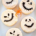 Five Jack Skellington-themed Halloween cookies arranged on a white plate.