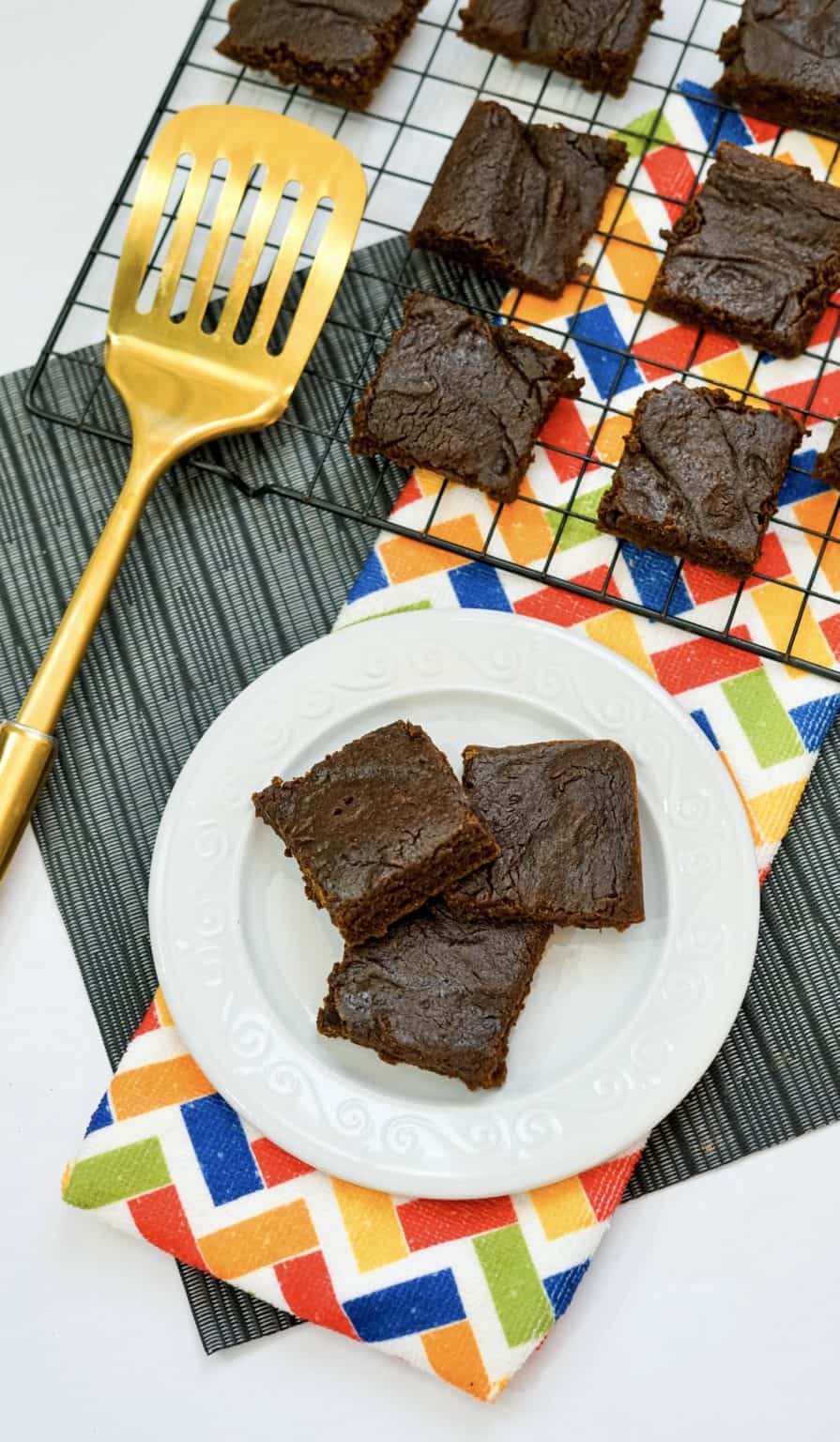 A chocolate brownie on a gold spatula.