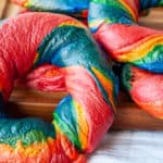Rainbow bagels in a chopping board.