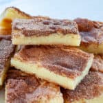 Three snickerdoodle bars on top of a pile of cookies.