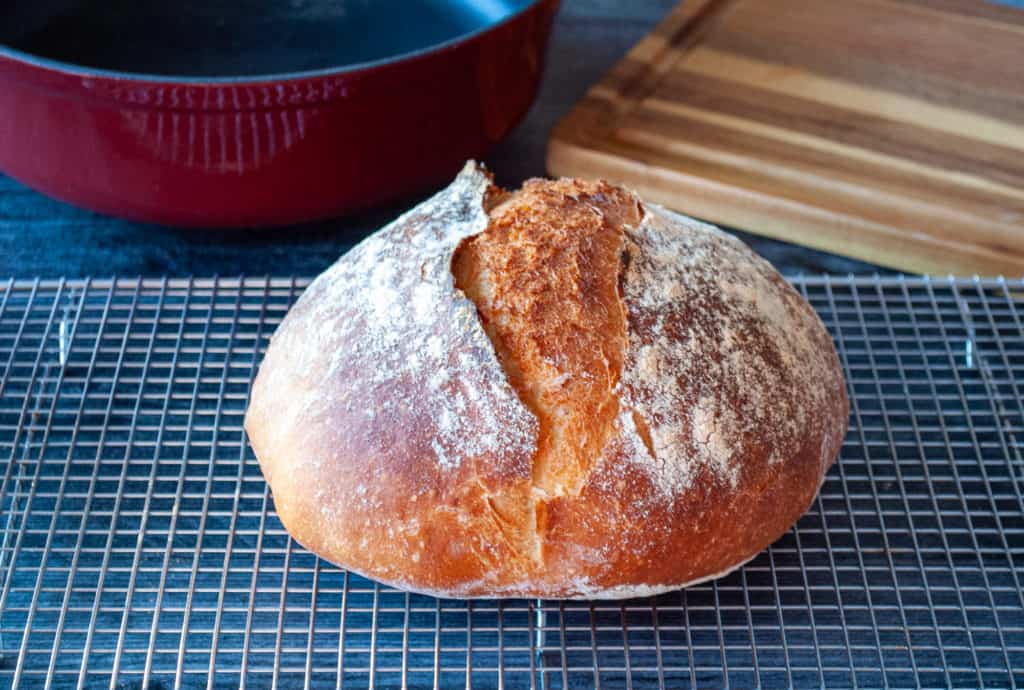 Dutch oven bread in front of a cast iron pot.