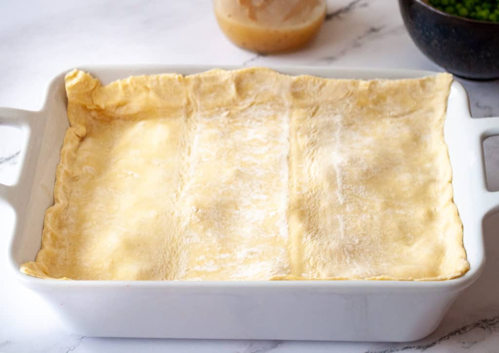 Pinch the puff pastry to the pan to keep the gravy from bubbling out over the top of the turkey pot pie. 