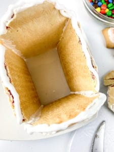 Adding the roof to your no-bake gingerbread house.