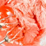 Adding the red food color paste or gel to the cookies dough.