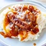 Bangers on mashed potatoes with onion gravy.