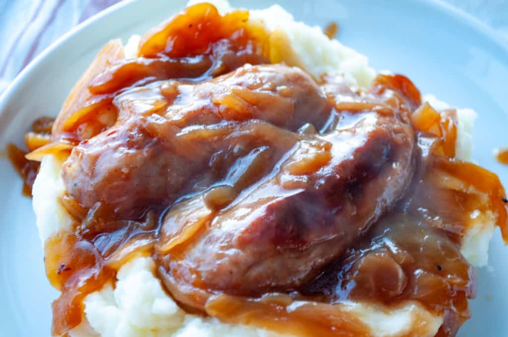 PLate with mash, bangers, and onion gravy.