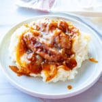 A plate of Easy Bangers and Mash topped with gravy.