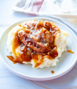 A plate of Easy Bangers and Mash topped with gravy.