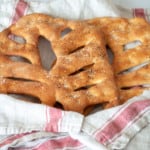 Two loaves of fougasse bread in a towel.