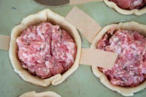Pork pies no top crust in a green muffin tin.
