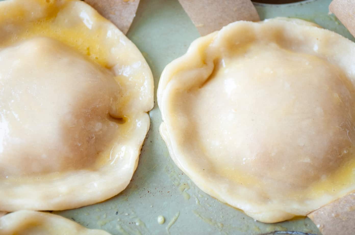 Mini pies brushed with egg wash.