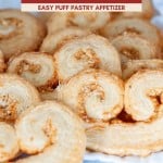 A close-up of golden, flaky savory palmiers—also known as cheese palmiers—arranged on parchment paper, with a label reading “Easy Puff Pastry Appetizer.”.