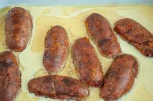 Sausages surrounded by yorkshire pudding batter.