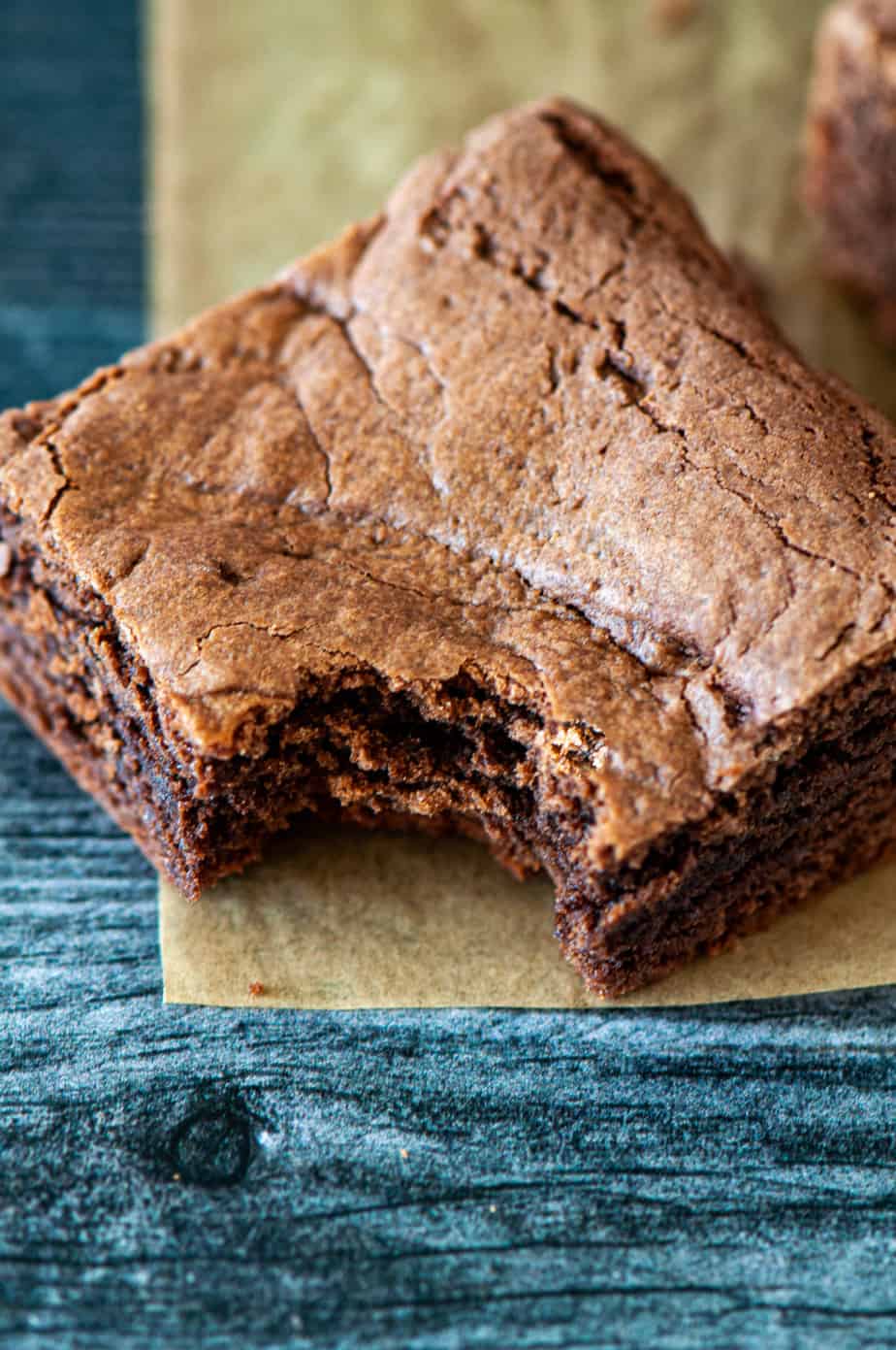 A stack of brownies and a milk bottle.