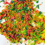Colorful DIY sprinkles scattered on a white surface.