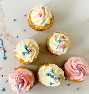 Cupcakes with colorful semi-homemade buttercream frosting and sprinkles on a marble surface.